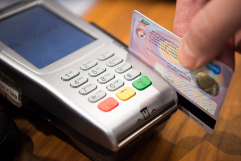 Cartão de crédito passando em uma maquina, alternativa de como levar dinheiro na viagem 